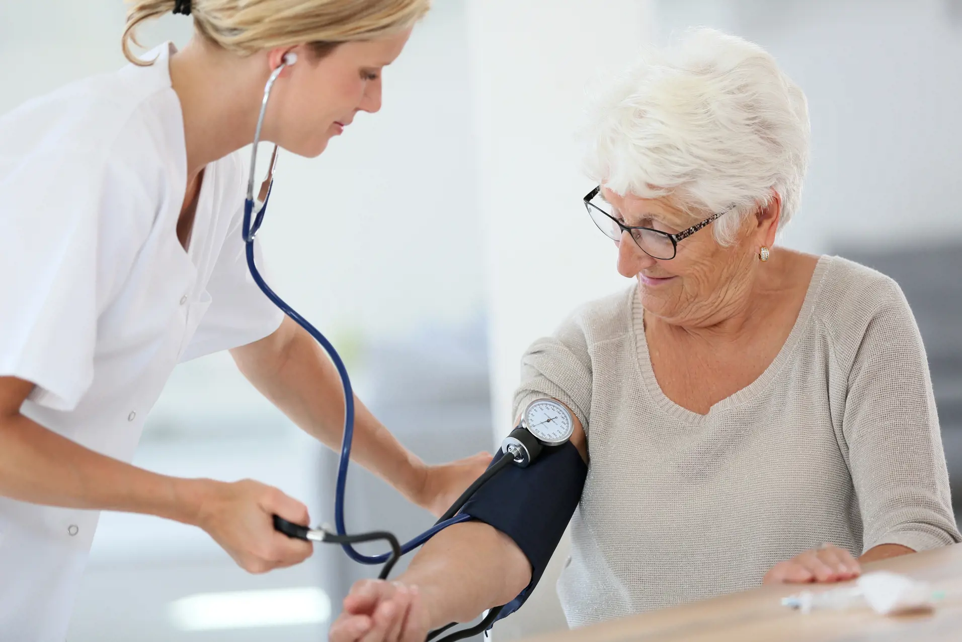 Sykepleier måler blodttrykk på pasient