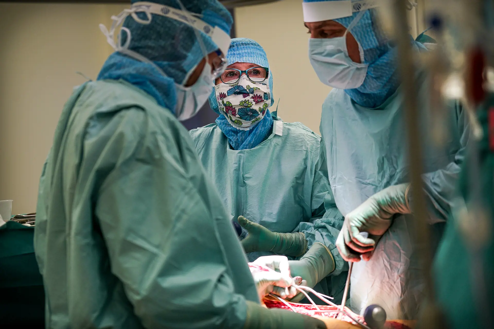 Bilde av tre operasjonssykepleiere under en operasjon.