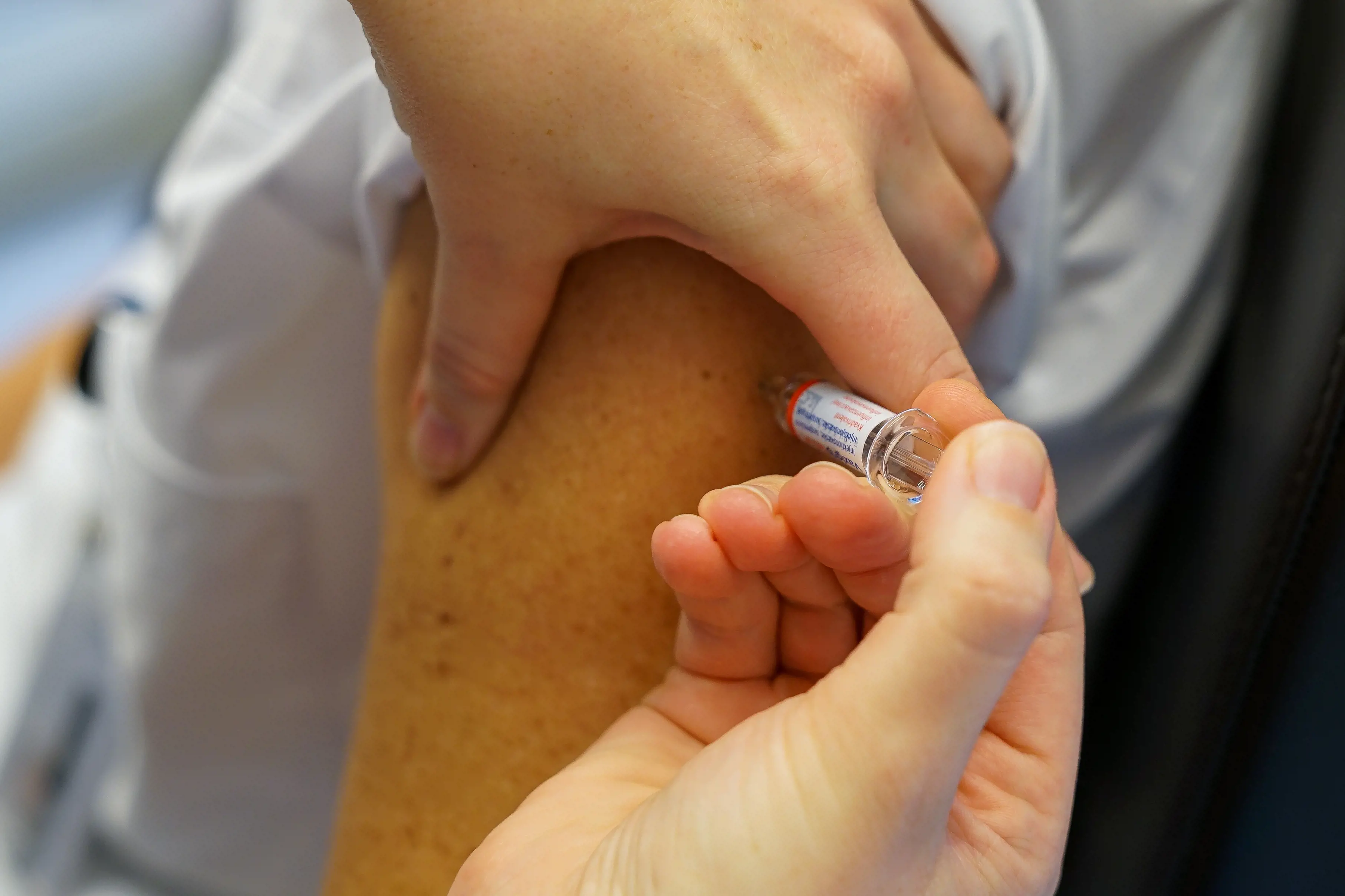 nærbilde av influensavaksine som settes i overarm