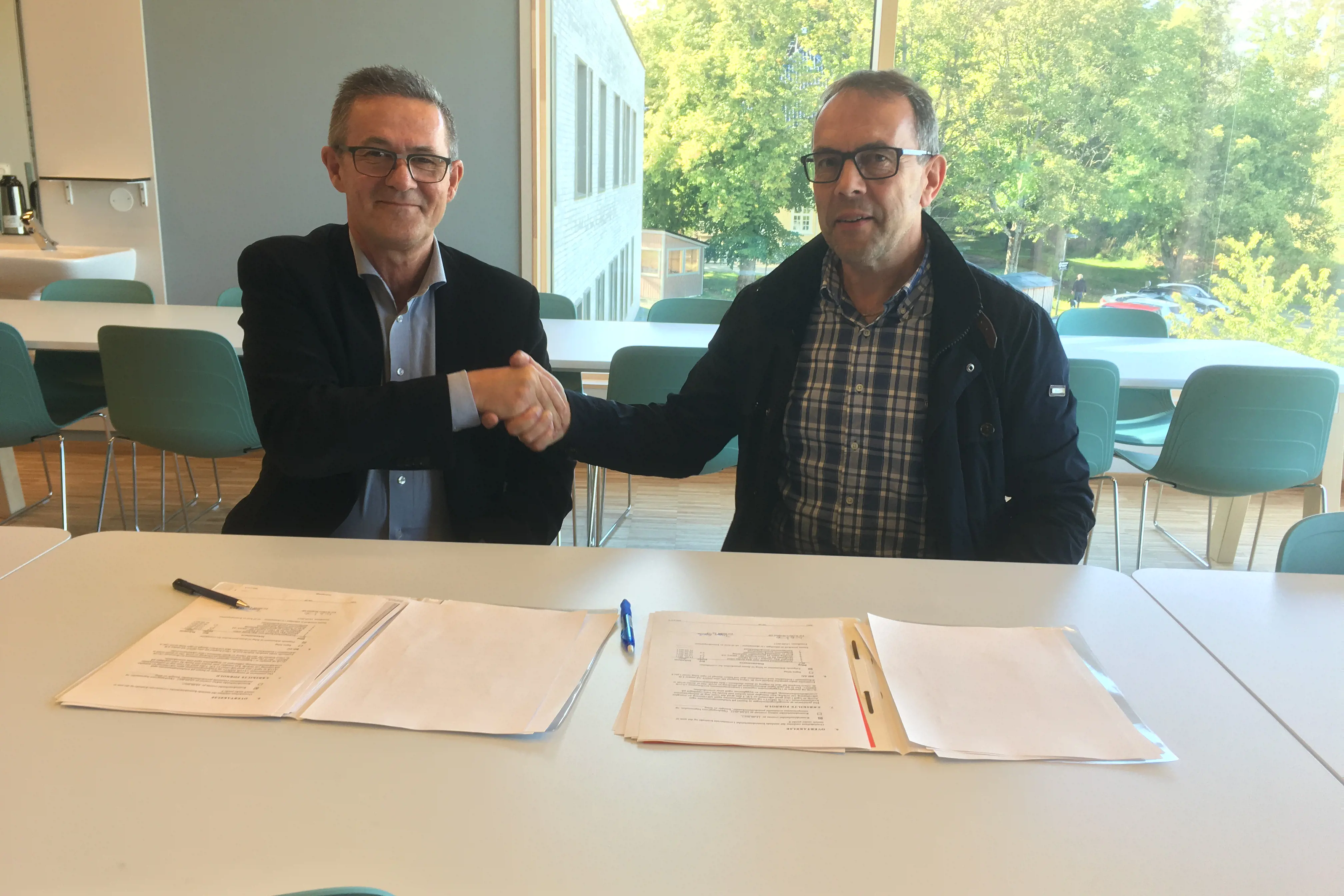 St. Olavs direktør Nils Kvernmo og Trygve Gjøvik fra HENT signerer overtakelsesprotokollen. Foto: Knut Ola Haug, Sykehusbygg
