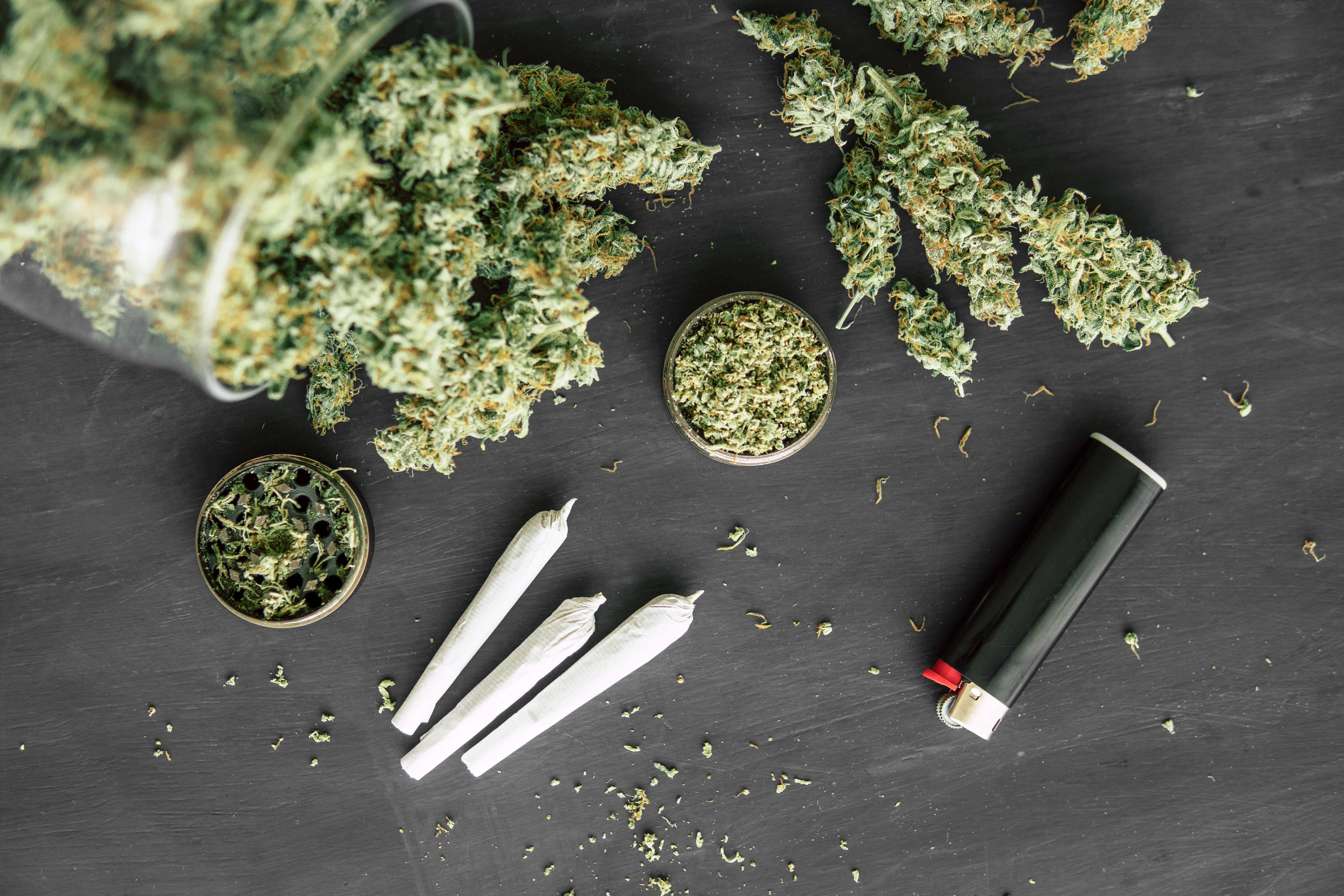 illlustrasjonsbilde med toppskudd av marihuana, en lighter og tre jointer